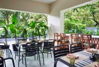 a restaurant with tables and chairs and plants at Radha House Siolim A Boutique Hotel in Oxel