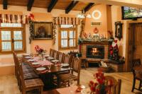 une salle à manger avec une table et une cheminée dans l'établissement Moslavačka Priča Holiday Homes, à Mala Ludina