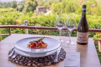 a table with a plate of pasta and two wine glasses at Vesuvio Inn Bed & Wine Experience in Boscotrecase