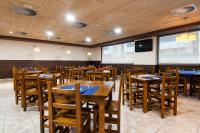 Un comedor con mesas y sillas de madera. en ibis Styles Pamplona Noain, en Noáin