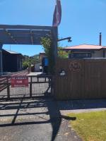 una valla delante de un edificio con un cartel en Al and Rosies B+B, en Greymouth