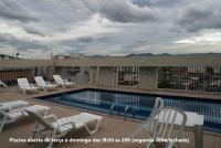 a swimming pool with lounge chairs on a rooftop at Flat Sirena - São Vicente in São Vicente
