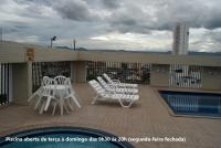 a group of white chairs sitting on a patio at Flat Sirena - São Vicente in São Vicente