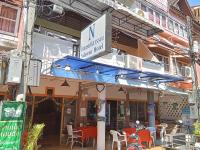a restaurant with a blue awning and tables and chairs at Nilawan Hotel in Hua Hin