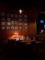 een tafel in een kamer met schilderijen aan een bakstenen muur bij Dad Residence in Lankaran