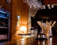 een bar met een tafel met een lamp en een kroonluchter bij Dad Residence in Lankaran