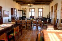 una sala da pranzo con tavoli e sedie in legno di Kardanakhi Estate a Anaga