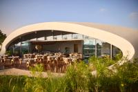 ḨanakShebara Resort的建筑物内有桌椅的餐厅