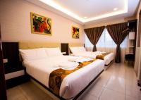 una habitación de hotel con dos camas en una habitación en Louis Hotel, en Taiping