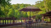 a table and chairs with an umbrella on a patio at Hotel Boutique Finca La Niebla in Coatepec