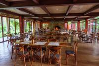 a restaurant with tables and chairs and a fireplace at Hotel Boutique Finca La Niebla in Coatepec