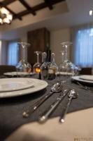 un tavolo con piatti e cucchiai e bicchieri di PineHill Hotel, Restaurant , Pool & Spa - RAZEM a Razëm