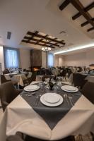 una sala per banchetti con un tavolo con piatti e posate di PineHill Hotel, Restaurant , Pool & Spa - RAZEM a Razëm