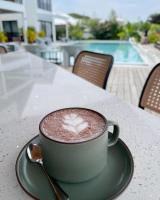 una taza de café sentada en una mesa con una cuchara en Natalna Boutique Home, en Bacnotan