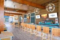 a dining room with a bar and chairs at Compass by Margaritaville Hotel Pigeon Forge in Pigeon Forge