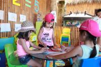 three girls wearing pink hats sitting at a table at Novotel Lombok Resort & Villas in Kuta Lombok