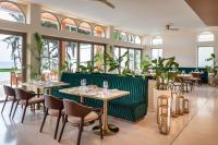 um restaurante com um banco verde e mesas e cadeiras em Radisson Collection Resort Galle em Galle