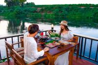 a man and woman sitting at a table on a boat at Tani Ryu River Kwai in Ban Tha Pong (1)
