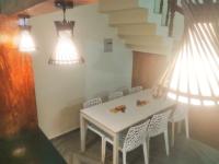 a dining room with a white table and chairs at Nirappil Tourist Home in Trivandrum