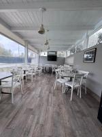 Un comedor con mesas y sillas y un televisor de pantalla plana. en Hotel Le Pinede Relax, en Licola