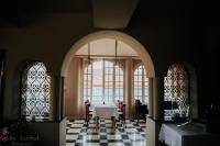 Un comedor con una mesa y dos ventanas. en Hôtel particulier des Jasmins, en Le Bar-sur-Loup