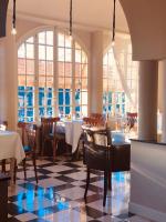 Un comedor con mesas y sillas y ventanas. en Hôtel particulier des Jasmins, en Le Bar-sur-Loup