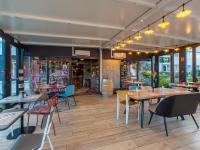 um restaurante com mesas, cadeiras e janelas em B&B HOTEL Orléans Nord Saran em Saran