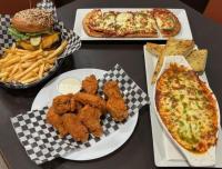 Una mesa cubierta con platos de comida con pizza y papas fritas. en Days Inn by Wyndham Calgary South, en Calgary
