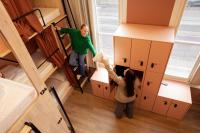 zwei Personen stehen in einem Zimmer mit Kisten in der Unterkunft The Elephant Hostel in Amsterdam