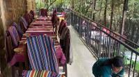 a woman standing in front of a row of tables at Inn of the Four Sisters in Gonder