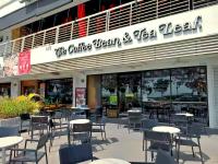 eine Terrasse mit Tischen und Stühlen vor einem Restaurant in der Unterkunft Maritime Suites Penang in Jelutong