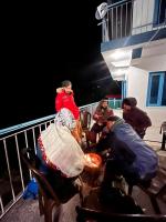 un grupo de personas sentadas en un balcón por la noche en Dhauladhar Eternals, en Dharamshala