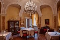 ein Esszimmer mit zwei Tischen und einem Kronleuchter in der Unterkunft Relais Castello di Razzano in Alfiano Natta