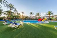 a resort with a pool with chairs and palm trees at Port Denia in Denia