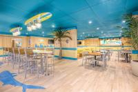 a restaurant with blue ceilings and tables and chairs at Margaritaville Resort Cape Cod in Hyannis