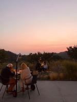 Corte D'Aibo في Monteveglio: مجموعة من الناس يجلسون على طاولة عند غروب الشمس