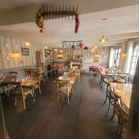 Le Patio في Évran: غرفة طعام مع طاولات وكراسي خشبية