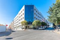 Un gran edificio en una calle de la ciudad con estacionamiento. en Port Feria Valencia, en Valencia