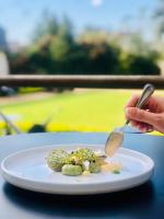 a person holding a spoon and a plate of food at Le Clos d'Amboise in Amboise