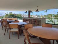 イポジュカにあるNovíssimo Makia Experience-Muro Alto em Porto de Galinhasのテーブルと椅子と大きな窓のあるレストラン