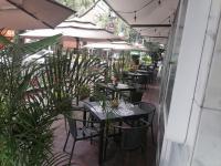 Un restaurante al aire libre con mesas, sillas y sombrillas. en Hotel Century Reforma, en Ciudad de México