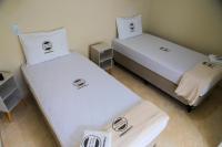 two beds in a room with white sheets at Pousada Mama África in Conservatória