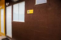a brown brick wall with two windows and a yellow sign at Pousada Mama África in Conservatória