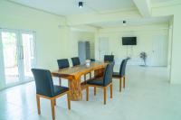 een houten tafel en stoelen in een kamer bij Farinda Resort & Pool Villa in Ban Huai Muang