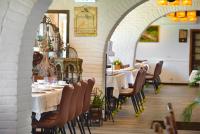 a dining room with tables and chairs and an archway at Oncoming Luck Villa in Renai