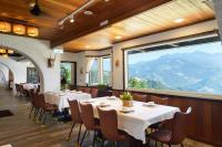 a restaurant with tables and chairs and a large window at Oncoming Luck Villa in Renai