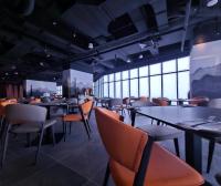 een restaurant met tafels en stoelen en een persoon op de achtergrond bij Signata Genting Highlands in Genting Highlands