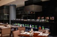 Un restaurante con mesas y sillas y una cocina. en Sofitel Cairo Downtown Nile, en El Cairo