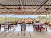 uma sala de jantar com mesas, cadeiras e janelas em Hotel 7Seas by Solara Hospitality em Vagator