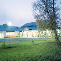 un edificio con un poste de luz en el césped en Hotelli Joentalo, en Tornio
